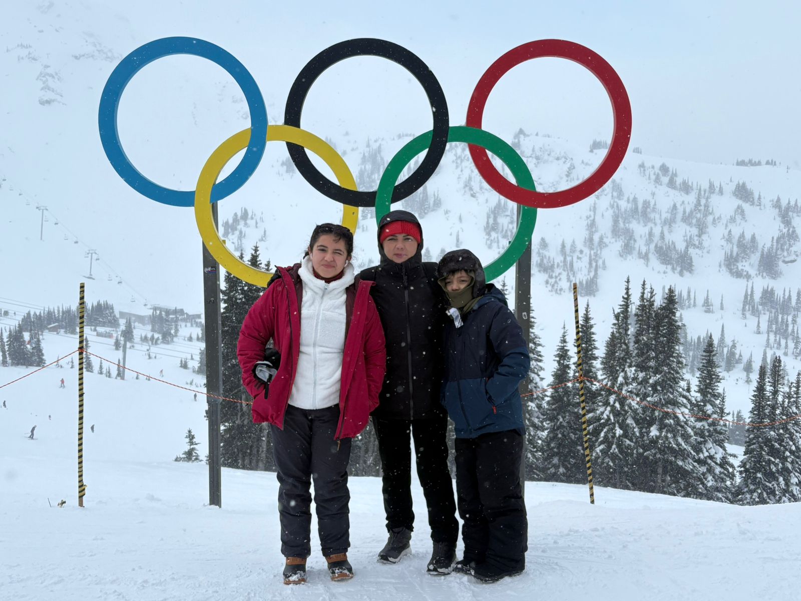 Familia frente a los aros olímpicos en la nieve