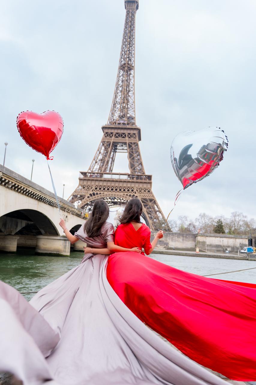 Amigas con globos de corazón frente a la Torre Eiffel, París