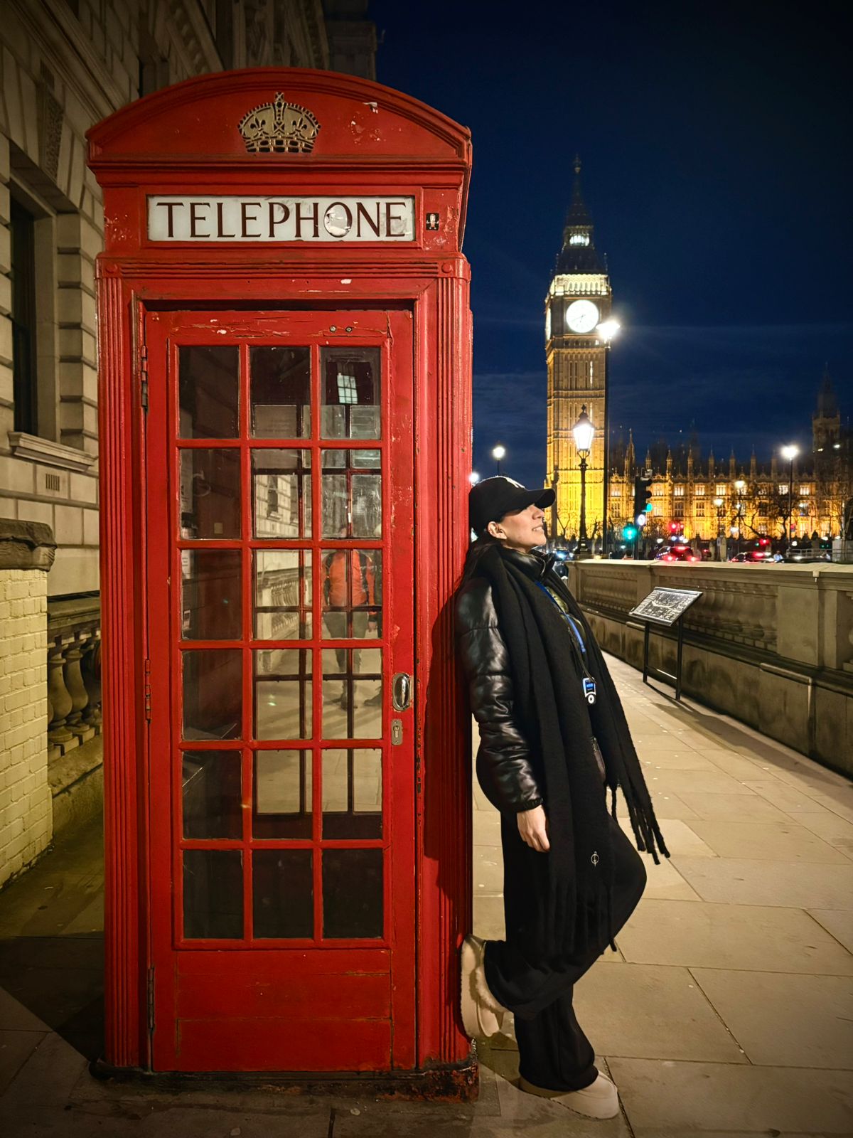 Viajera junto a una cabina telefónica roja con el Big Ben de fondo, Londres